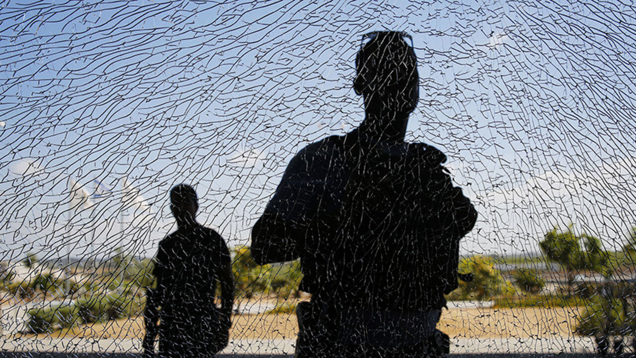 Israeli security personnel look at a window damaged by shrapnel after a short-range rocket landed on Tuesday near the Erez crossing Israeli security personnel look at a window damaged by shrapnel after a short-range rocket landed on Tuesday near the Erez crossing July 16, 2014. An Israeli civilian was killed by the rocket fired from the Gaza Strip on Tuesday, the military said, the first Israeli fatality in more than a week of fighting with Palestinian militants. The Islamist group Hamas that rules Gaza claimed responsibility for launching the short-range rocket that struck an area along the border with Gaza. REUTERS/Finbarr O'Reilly (I