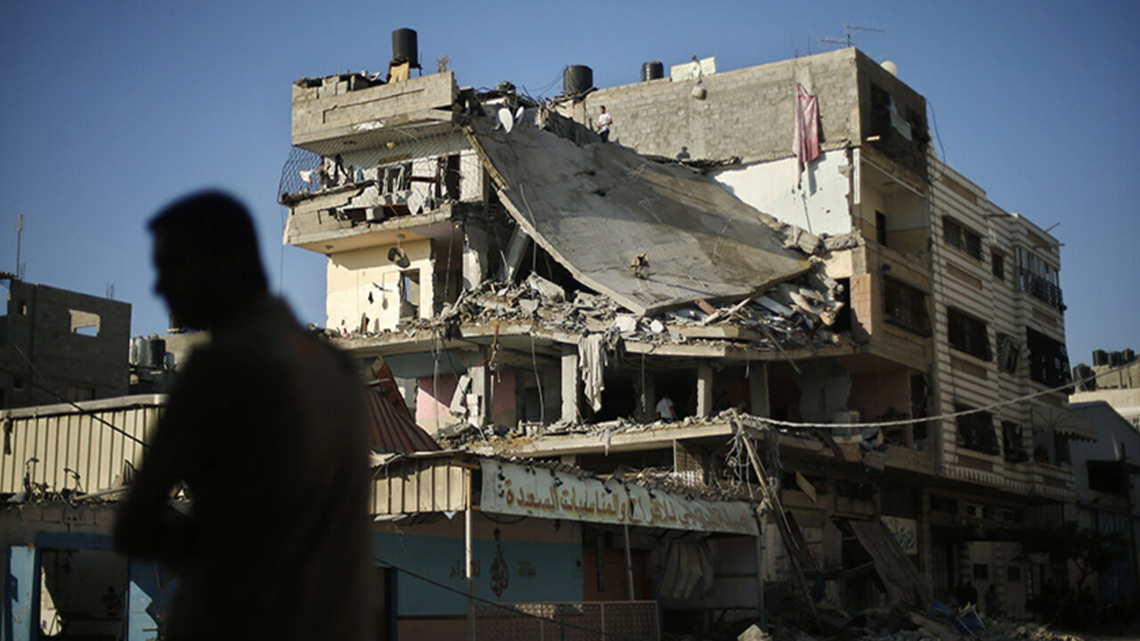 A Palestinian man stands next to a house which police said was targeted in an Israeli air strike in Gaza City July 17, 2014. Israeli shelling killed four Palestinian boys on a Gaza beach on Wednesday, an incident the military called tragic, and Israel and Hamas said they would cease attacks for five hours on Thursday for a humanitarian truce requested by the United Nations. Palestinian militants fired more than 130 rockets into Israel on the ninth day of a war in which Israeli attacks have killed 216 Palest