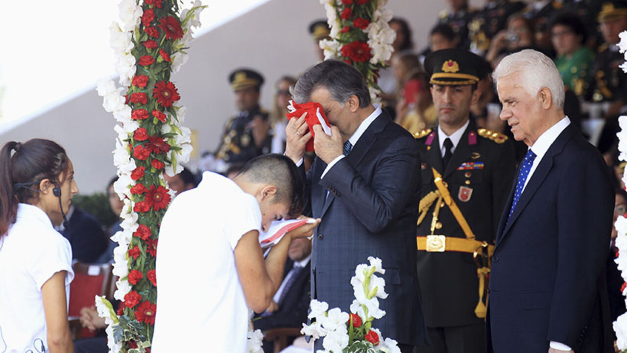Turkish President Abdullah Gul exchanges flags with Turkish Cypriot youth during military parade marking 40 years from the invasion of northern Cyprus, in Nicosia Turkish President Abdullah Gul (R) exchanges flags with a Turkish Cypriot youth during a military parade marking 40 years from the invasion of northern Cyprus, in the Cypriot capital Nicosia July 20 2014. Turkish forces landed on the island four decades ago in response to a brief Greek Cypriot coup, partitioning the island since. REUTERS/Andreas Manolis (CYPRUS - Tags: POLITICS ANNIVERSARY MILITARY) - RTR3ZEDW