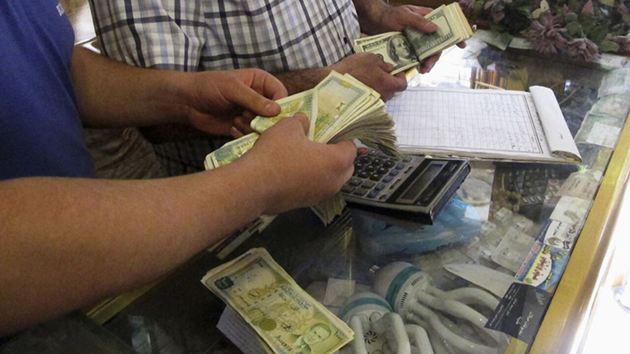 Money changers count Syrian pound notes and U.S dollars at a currency exchange shop in Aleppo Money changers count Syrian pound notes and U.S dollars at a currency exchange shop in Aleppo's Bustan al-Qasr district, September 9, 2013. Picture taken September 9, 2013. REUTERS/Abdalghne Karoof (SYRIA - Tags: POLITICS CIVIL UNREST CONFLICT BUSINESS) - RTX13FMH