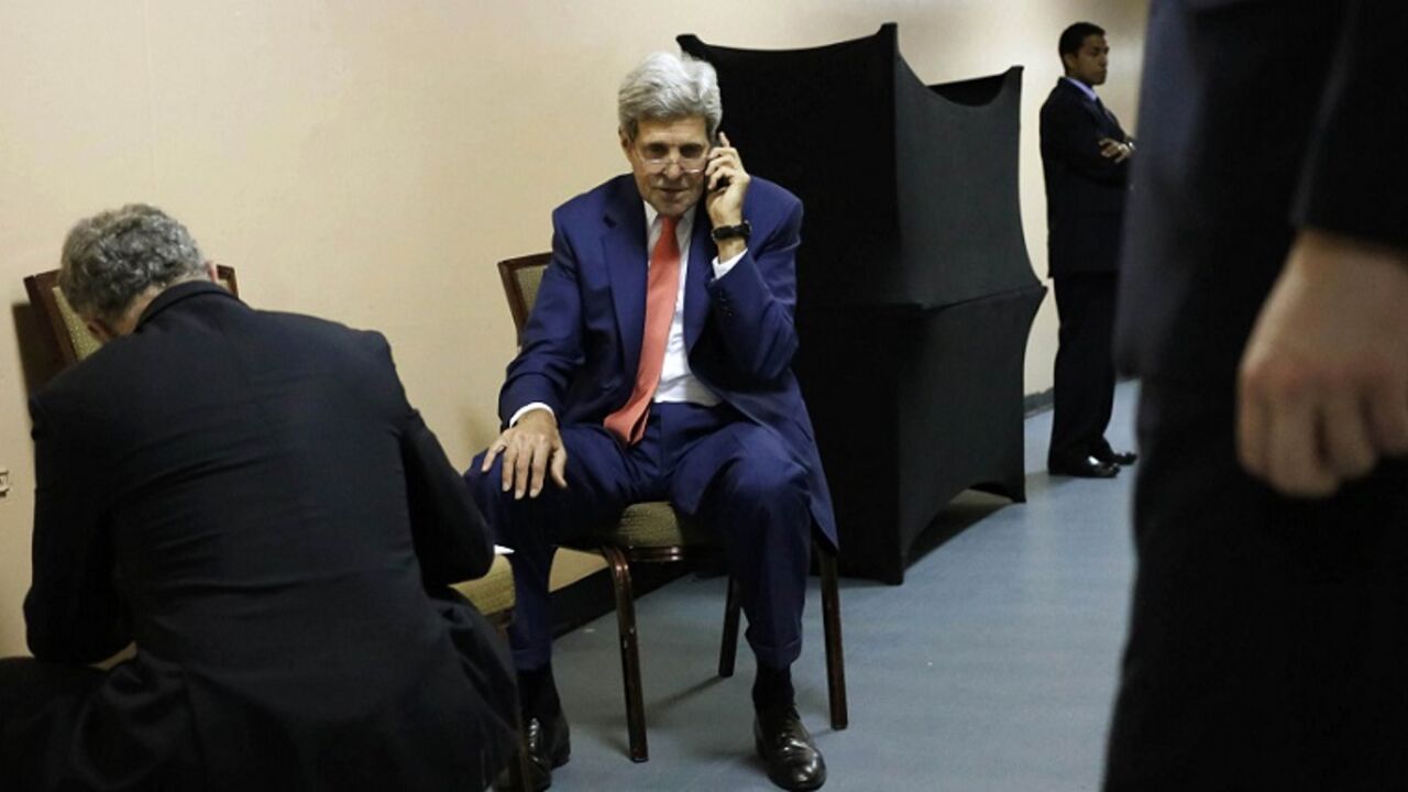 U.S. Secretary of State Kerry speaks on the phone to Qatar's FM Attiyah from a hotel in Cairo U.S. Secretary of State John Kerry (C), surrounded by aides, sits in the service hallway of a hotel in Cairo July 25, 2014, as he speaks on the phone with Qatar's Foreign Minister Khaled al-Attiyah about the terms of a ceasefire in Israel's fight against Islamist militants in Gaza, during a break in his meetings with Egypt's Foreign Minister Sameh Shukri and U.N. Secretary-General Ban Ki-moon. Kerry said on Friday that there are still disagreements on the terminology for a Gaza truce but he is confident the