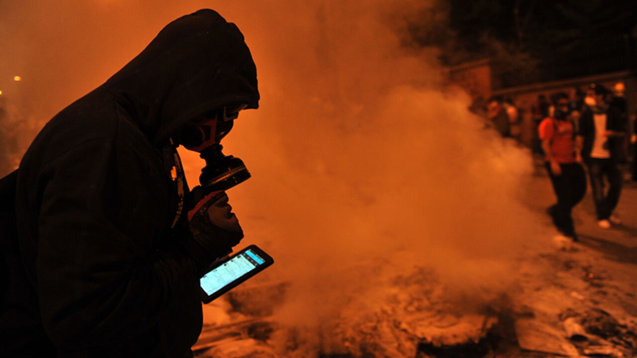 TURKEY-POLITICS-PROTEST A protestor uses Facebook on mobile phone to give latestt news about the clashes near Taksim in Istanbul on June 3, 2013 during a demonstration against the demolition of the park. Turkish police on June 1 began pulling out of Istanbul's iconic Taksim Square, after a second day of violent clashes between protesters and police over a controversial development project. Thousands of demonstrators flooded the site as police lifted the barricades around the park and began withdrawing from the square. What started