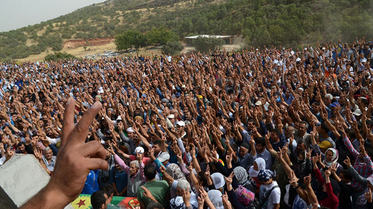 TURKEY-KURDS-UNREST A picture taken on August 19, 2014 shows people making the victory sign as they attend the funeral ceremony of Mehdi Taskin, 24, who died during clashes that erupted between protesters and security forces during an operation to remove a statue of Mahsum Korkmazare, one of the founders of the outlawed Kurdistan Workers Party (PKK). One person was killed and two were wounded in the clashes that erupted when a group of protesters gathered at the cemetery to prevent security forces from removing the statue. Meh