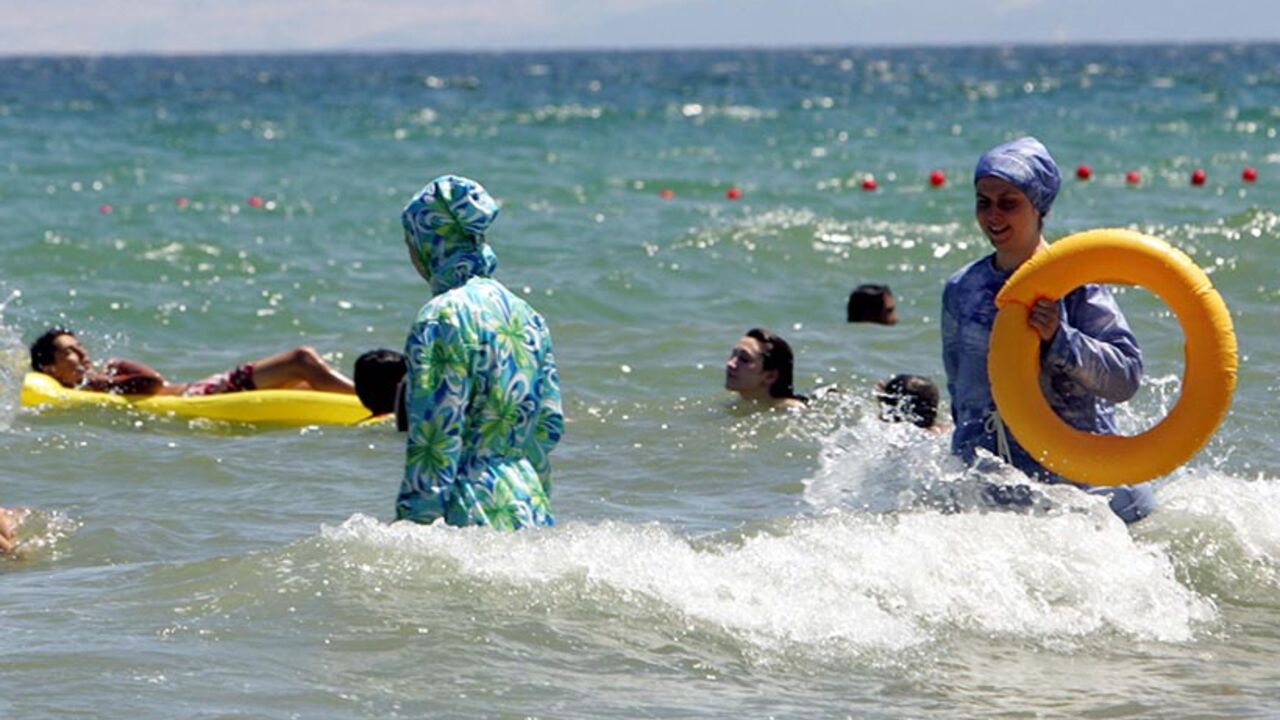 TO GO WITH AFP STORY BY BURAK AKINCI Tu Istanbul, TURKEY: TO GO WITH AFP STORY BY BURAK AKINCI Turkish women wearing a "hasema", an islamic bathing suit, swim 18 August 2006 at the beach near Istanbul. Last week in Karaburun, a resort near Izmir, a young women was assaulted by a group of Islamists because she was wearing a bikini. AFP PHOTO/MUSTAFA OZER (Photo credit should read MUSTAFA OZER/AFP/Getty Images)