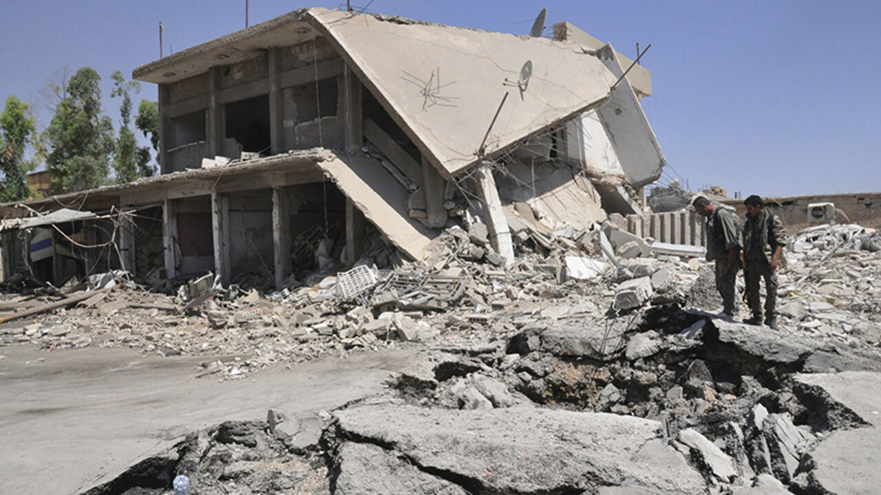 Residents inspect damage at a site which activists said was caused by a suicide bomber in the middle of a market last night in Tirbespiye village, east Qamishli Residents inspect damage at a site which activists said was caused by a suicide bomber in the middle of a market last night in Tirbespiye village, east Qamishli, June 15, 2014. Activists claim that 14 people died due to the explosion, seven of them are Arab and the other seven are Kurds, while 25 were injured. REUTERS/Massoud Mohammed (SYRIA - Tags: POLITICS CIVIL UNREST CONFLICT) - RTR3TWNH