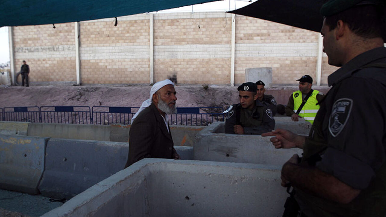 Israeli border police officer speaks with a Palestinian man as he waits to cross into Jerusalem to attend the first Friday prayer of Ramadan in al-Aqsa mosque, at Qalandia checkpoint near Ramallah An Israeli border police officer speaks with a Palestinian man as he waits to cross into Jerusalem to attend the first Friday prayer of Ramadan in al-Aqsa mosque, at Qalandia checkpoint near the West Bank city of Ramallah July 4, 2014. REUTERS/Mohamad Torokman (WEST BANK - Tags: POLITICS RELIGION SOCIETY) - RTR3X1TV