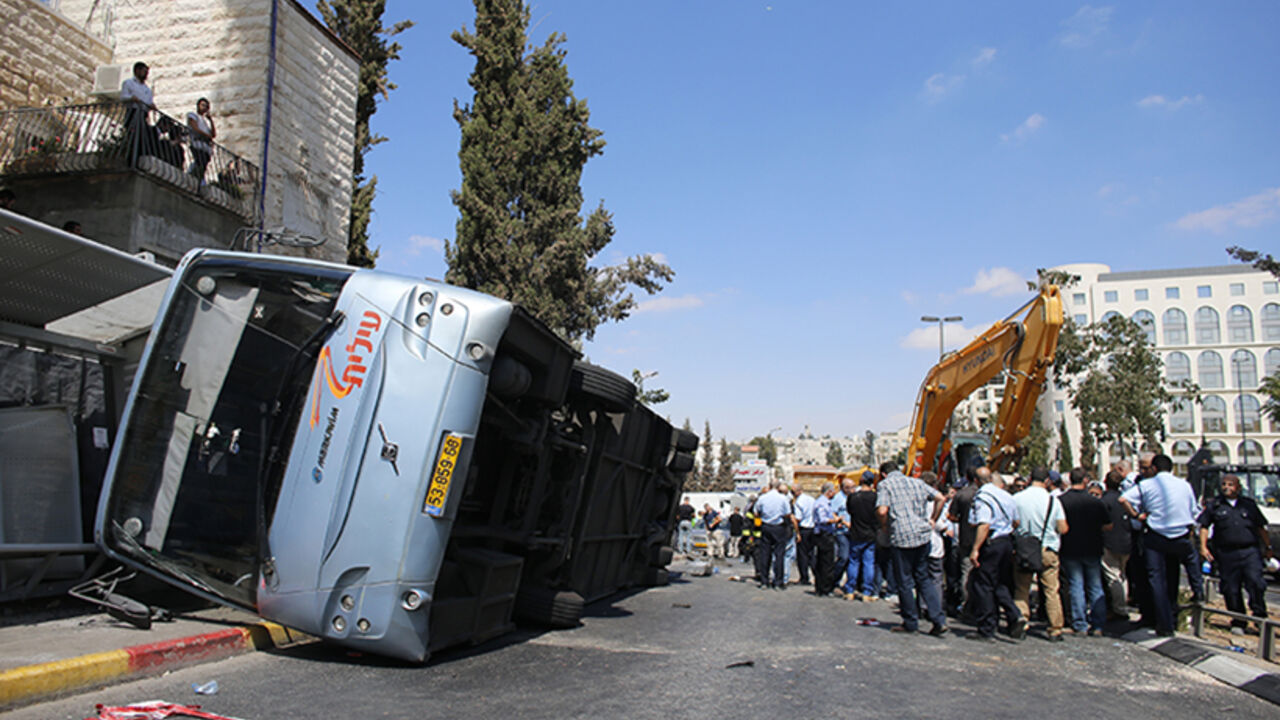 An overturned bus lies at the scene of a suspected attack in Jerusalem An overturned bus lies at the scene of a suspected attack in Jerusalem August 4, 2014. A construction vehicle hit and killed a pedestrian and overturned the bus on a main street in Jerusalem on Monday in what police suspect was a Palestinian attack, which ended when policemen shot dead the driver of the yellow excavator. REUTERS/Ammar Awad (JERUSALEM - Tags: POLITICS CIVIL UNREST) - RTR41625