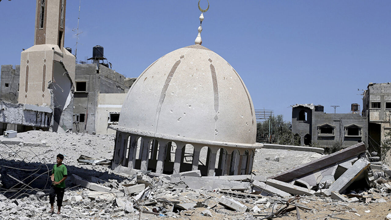 Palestinian boy stands next to the remains of a mosque in Khuzaa town in the southern Gaza Strip A Palestinian boy stands next to the remains of a mosque in Khuzaa town, which witnesses said was heavily hit by Israeli shelling and air strikes during Israeli offensive, in the east of Khan Younis in the southern Gaza Strip August 6, 2014. With its spacious villas and palm-lined streets, the town of Khuzaa in southern Gaza gave Palestinians a rare place to spend their free time before it was bombed and shelled to rubble last month. Largely free of the local tensions and feuds found in other neighbourhoods