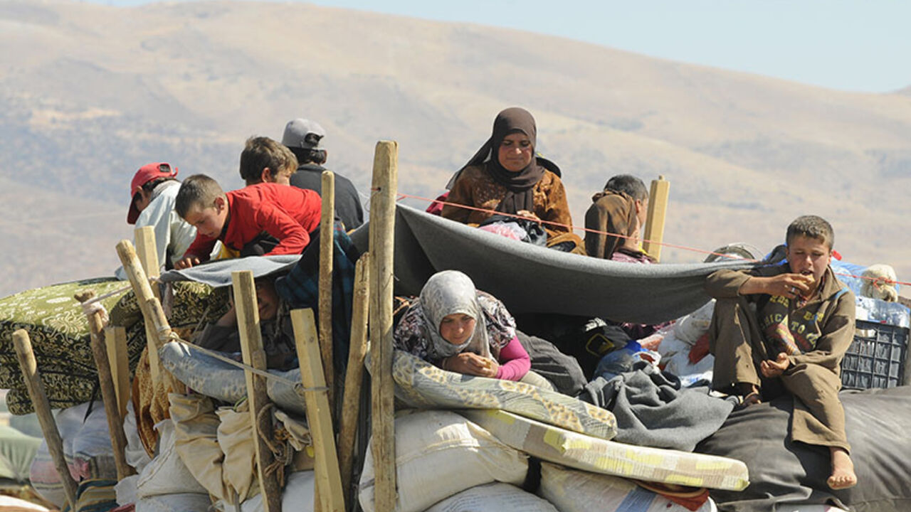 Syrian refugees, fleeing the recent fighting in Arsal, wait with their belongings in Majdel Anjar in the Bekaa valley, near the Lebanese border with Syria Syrian refugees, fleeing the recent fighting in Arsal, wait with their belongings in Majdel Anjar in the Bekaa valley, near the Lebanese border with Syria August 8, 2014. The refugees, who had sought shelter in Arsal, were attempting to head back to Syria; however, they say Syrian authorities at the border rejected them until further investigation to verify their identities and statuses. REUTERS/Hassan Abdallah (LEBANON - Tags: POLITICS CIVIL UNREST) - RTR41Q6X