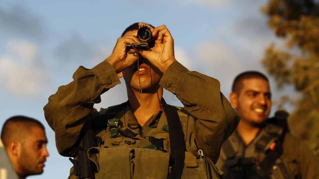 An Israeli soldier looks at the Gaza Strip through a monocular on the Israeli border An Israeli soldier looks at the Gaza Strip through a monocular on the Israeli border August 9, 2014. Israel launched more than 30 air attacks in Gaza on Saturday, killing five Palestinians, and militants fired rockets at Israel as the conflict entered a second month, defying international efforts to revive a ceasefire. REUTERS/Amir Cohen (ISRAEL - Tags: POLITICS CONFLICT MILITARY TPX IMAGES OF THE DAY) - RTR41TE3
