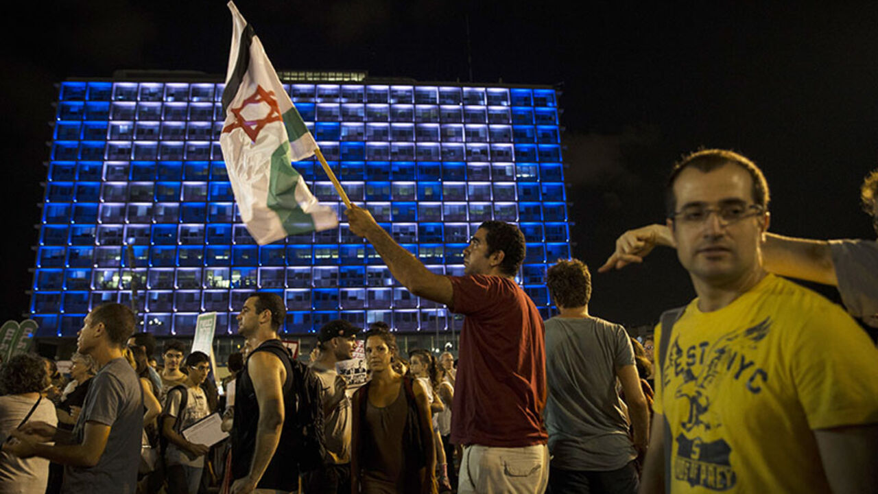 A man holds up a flag during a peace rally in Tel Aviv's Rabin Square A man holds up a flag during a peace rally in Tel Aviv's Rabin Square August 16, 2014. The protesters were demonstrating in favour of a peaceful political agreement, to end the month-long conflict in Gaza, between the Israeli and Palestinian governments.
REUTERS/Baz Ratner (ISRAEL - Tags: POLITICS CIVIL UNREST TPX IMAGES OF THE DAY) - RTR42O64