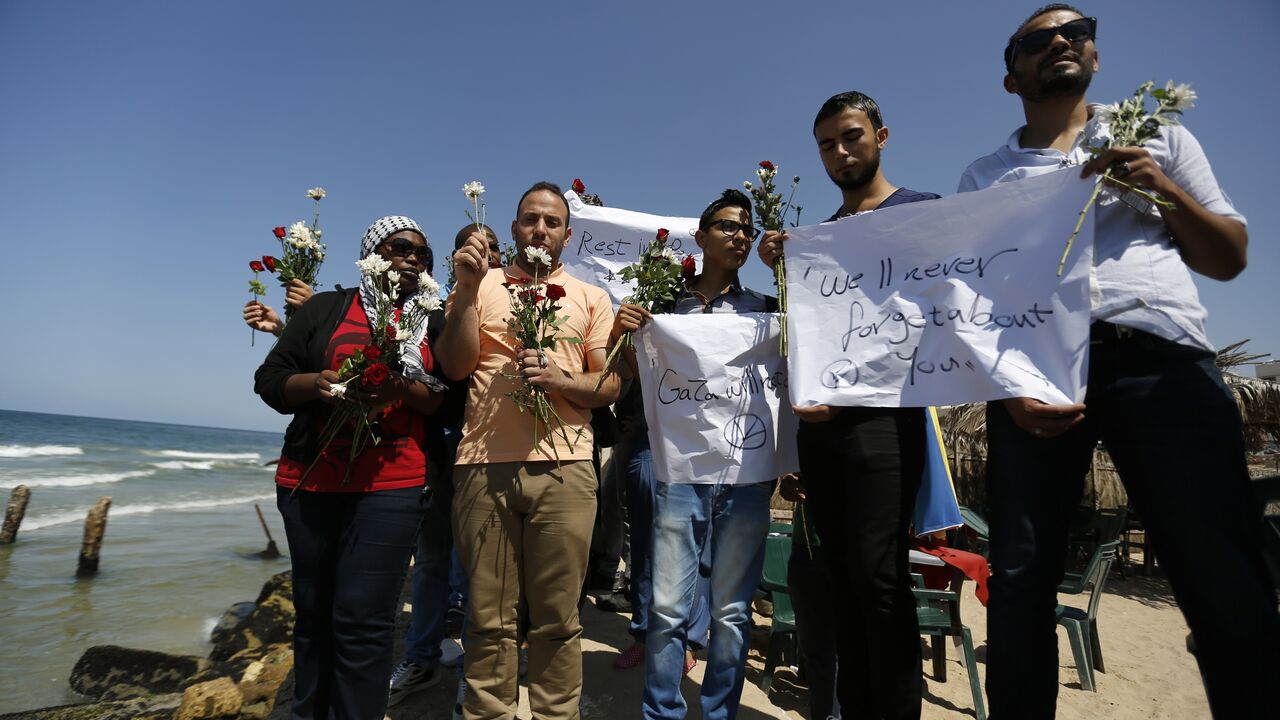 PALESTINIAN-ISRAEL-CONFLICT-GAZA-BOAT-IMMIGRATION A group of Palestinians prepare to throw roses in the Mediterranean sea off the coast of Gaza City on September 18, 2014 in mourning over the loss of fellow Palestinians who had boarded a boat to Europe that sank off Malta last week. In one of the deadliest migrant shipwrecks on record, the boat, with 500 people on board, was intentionally capsized by traffickers as it made its way from Egypt to Italy. Only 10 people are known to have survived, among them four Palestinians from the 100 Gazans believed to ha