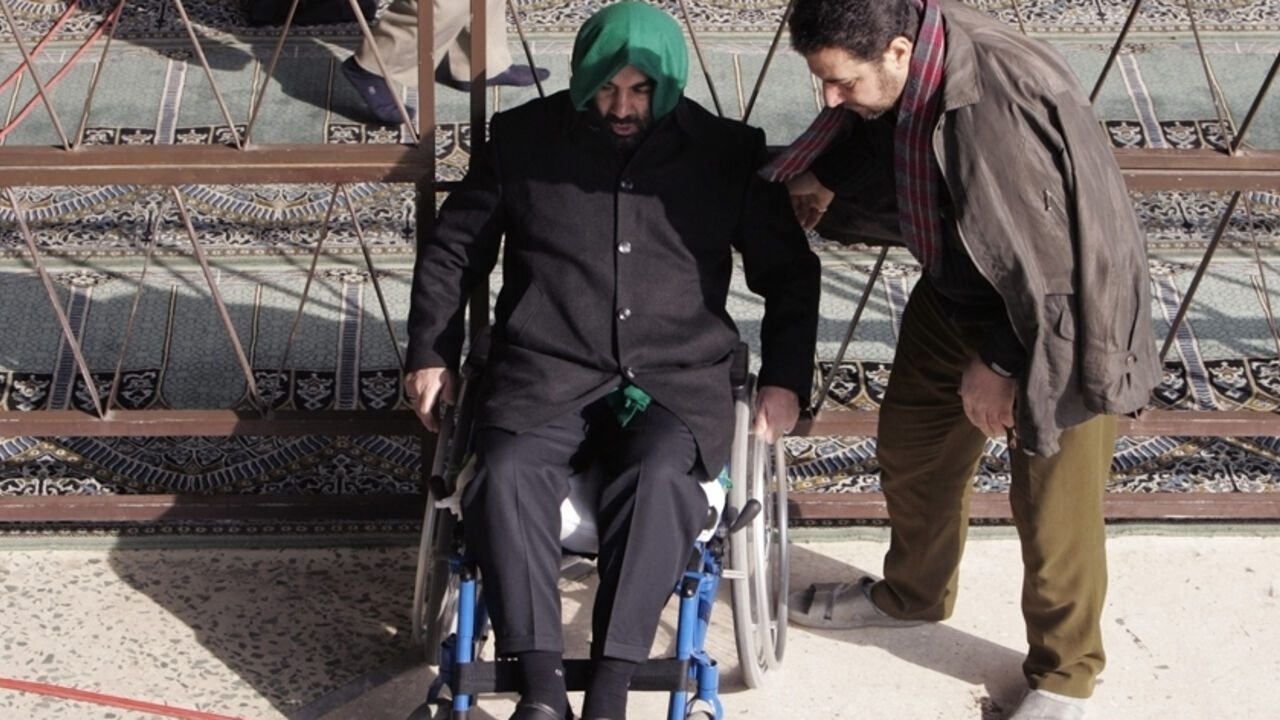 A man helps a veteran of the war between Iraq and Iran during Friday prayers in Tehran A man helps a veteran of the war between Iraq and Iran during Friday prayers in Tehran January 5, 2007. REUTERS/Raheb Homavandi (IRAN) - RTR1KWIB