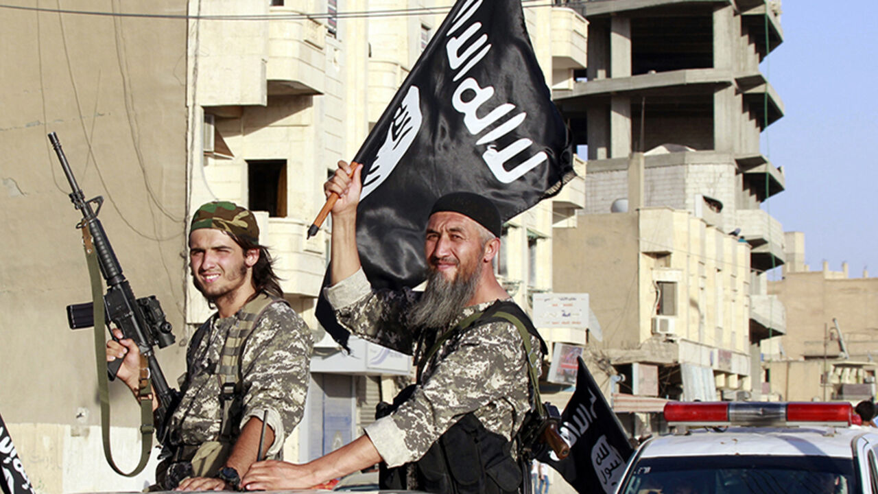 Militant Islamist fighters wave flags as they take part in a military parade along the streets of Syria's northern Raqqa province Militant Islamist fighters wave flags as they take part in a military parade along the streets of Syria's northern Raqqa province June 30, 2014. The fighters held the parade to celebrate their declaration of an Islamic "caliphate" after the group captured territory in neighbouring Iraq, a monitoring service said. The Islamic State, an al Qaeda offshoot previously known as Islamic State in Iraq and the Levant (ISIL), posted pictures online on Sunday of people waving black flags from cars and holding guns in