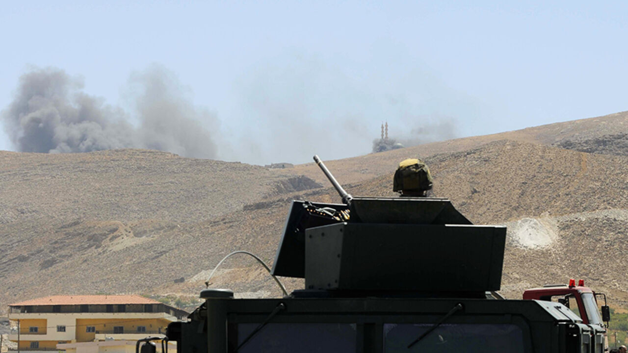 Lebanese army soldier sits atop army vehicle at the entrance of the Sunni Muslim border town of Arsal, in eastern Bekaa Valley, as smoke rises during clashes between Lebanese army soldiers and Islamist militants A Lebanese army soldier sits atop an army vehicle at the entrance of the Sunni Muslim border town of Arsal, in eastern Bekaa Valley, as smoke rises during clashes between Lebanese army soldiers and Islamist militants August 4, 2014. The Lebanese army advanced into a border town that was attacked by Islamists in an incursion from Syria at the weekend, finding the bodies of 50 militants, a Lebanese security official said. REUTERS/Hassan Abdallah (LEBANON - Tags: POLITICS CIVIL UNREST MILITARY TPX IMAGE