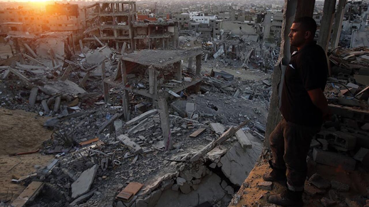 A Palestinian man looks out of his heavily damaged house at neighbouring houses which witnesses said were destroyed during the Israeli offensive, in the east of Gaza A Palestinian man looks out of his heavily damaged house at neighbouring houses which witnesses said were destroyed during the Israeli offensive, in the east of Gaza City September 3, 2014. An open-ended ceasefire between Israel and Hamas-led Gaza militants, mediated by Egypt, took effect on August 26 after a seven-week conflict. It called for an indefinite halt to hostilities, the immediate opening of Gaza's blockaded crossings with Israel and Egypt, and a widening of the territory's fishing zone in the Me
