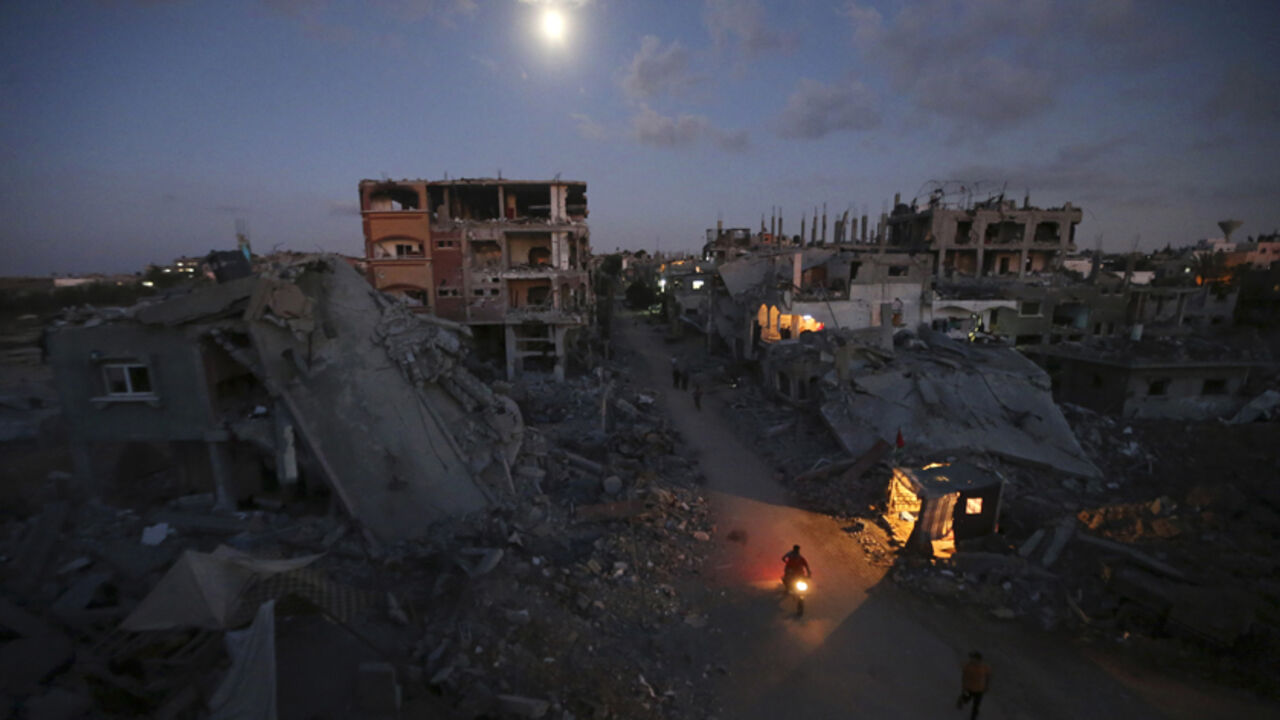 Palestinians commute along a road between ruins of houses, which witnesses said were damaged or destroyed during the Israeli offensive, in Beit Hanoun Palestinian pedestrians and a motorcyclist commute along a road between ruins of houses, which witnesses said were damaged or destroyed during the Israeli offensive, in Beit Hanoun town in the northern Gaza Strip September 7, 2014. An open-ended ceasefire between Israel and Hamas-led Gaza militants, mediated by Egypt, took effect on August 26 after a seven-week conflict. It called for an indefinite halt to hostilities, the immediate opening of Gaza's blockaded crossings with Israel and Egypt, and a widening