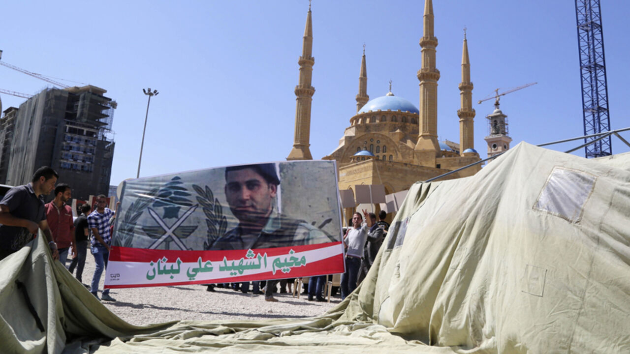Relatives of Lebanese soldiers and policemen erect a tent and hold a banner depicting a Lebanese soldier during an open-ended sit-in in Beirut Relatives of Lebanese soldiers and policemen, who were captured by Islamist militants in Arsal, erect a tent and hold a banner depicting Lebanese soldier Ali al-Sayyed, who was beheaded by IS militants, during an open-ended sit-in demanding for the release of the remaining soldiers and pressuring the government to act in Martyrs' Square in downtown Beirut September 10, 2014. Islamic State militants have beheaded a captive Lebanese soldier, images published on social media showed on Saturday, the second Leba