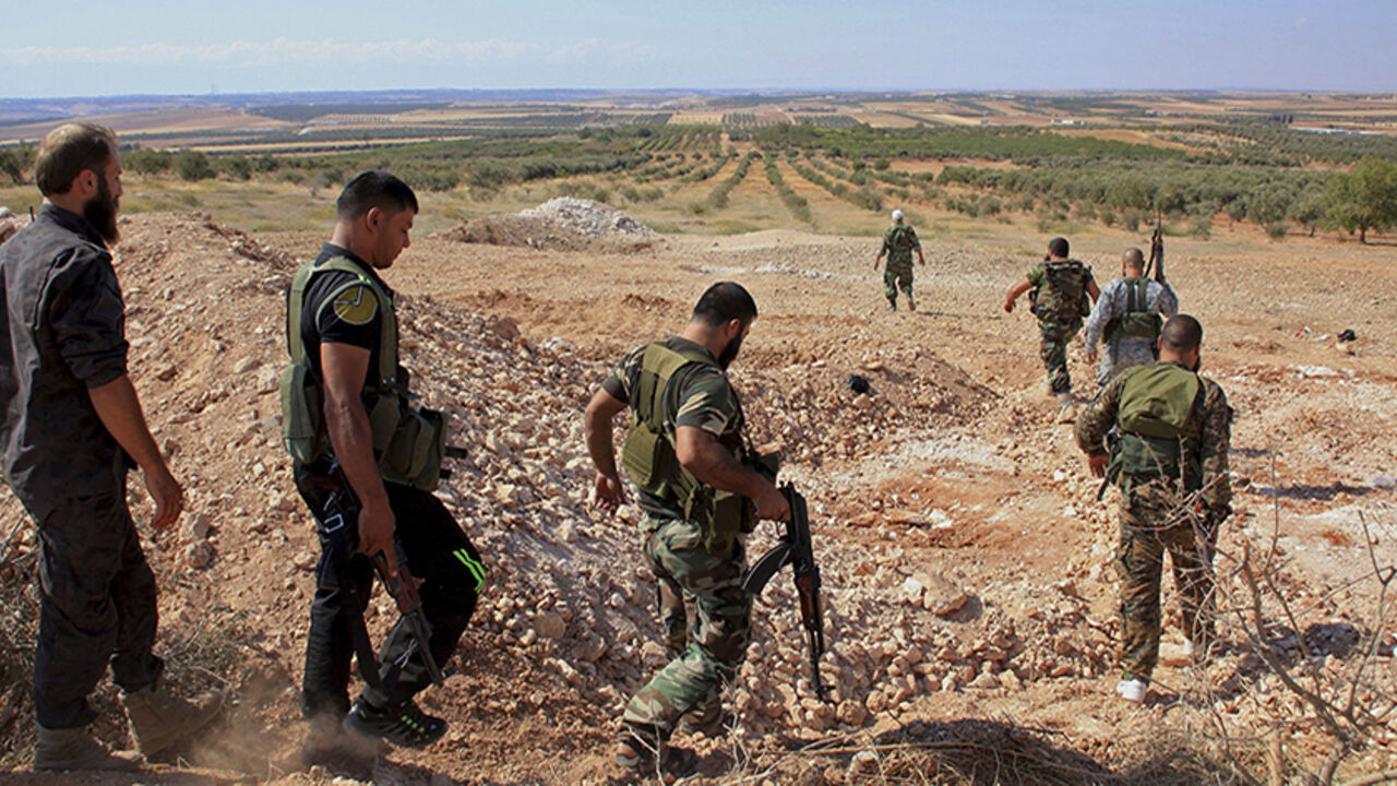 Forces loyal to Syria's President Assad carry their weapons as they walk in the village and hill of Al-Samsam Forces loyal to Syria's President Bashar al-Assad carry their weapons as they walk in the village and hill of Al-Samsam in Hama countryside, after saying they have regained control of the area September 13, 2014. REUTERS/George Ourfalian (SYRIA - Tags: POLITICS CIVIL UNREST CONFLICT MILITARY) - RTR463AI