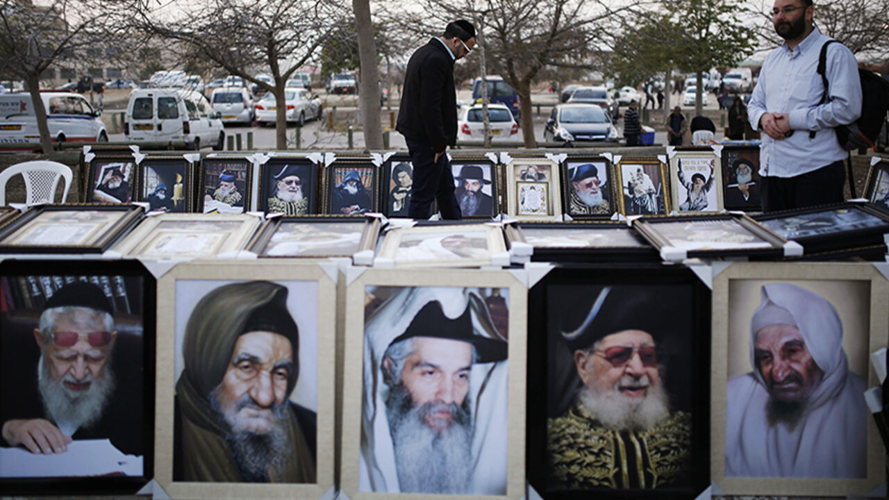 Jewish worshippers walk between images of rabbis offered for sale during an annual pilgrimage to the gravesite of Rabbi Yisrael Abuhatzeira in Netivot Jewish worshippers walk between images of rabbis offered for sale during an annual pilgrimage to the gravesite of Rabbi Yisrael Abuhatzeira, a Moroccan-born sage and kabbalist also known as the Baba Sali, on the anniversary of his death in the southern town of Netivot, January 5, 2014. REUTERS/Amir Cohen (ISRAEL - Tags: ANNIVERSARY RELIGION TPX IMAGES OF THE DAY) - RTX1735D
