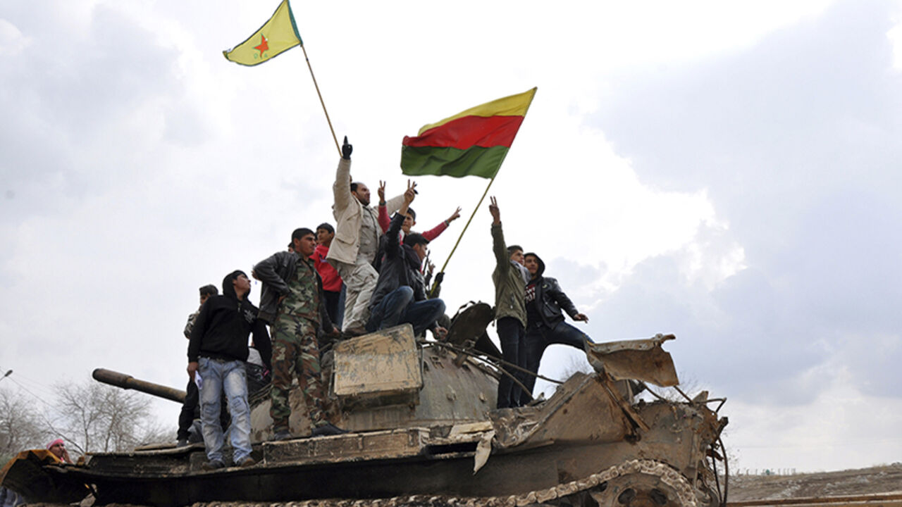 Civilians and members of the YPG gesture and raise flags atop a tank that belonged to fighters from the ISIL, in al-Manajeer village of Ras al-Ain countryside Civilians and members of the Kurdish People's Protection Units (YPG) gesture and raise flags atop a tank that belonged to fighters from the al Qaeda-affiliated Islamic State of Iraq and the Levant (ISIL), in al-Manajeer village of Ras al-Ain countryside January 28, 2014. REUTERS/Rodi Said (SYRIA - Tags: POLITICS CIVIL UNREST CONFLICT) - RTX17YNR