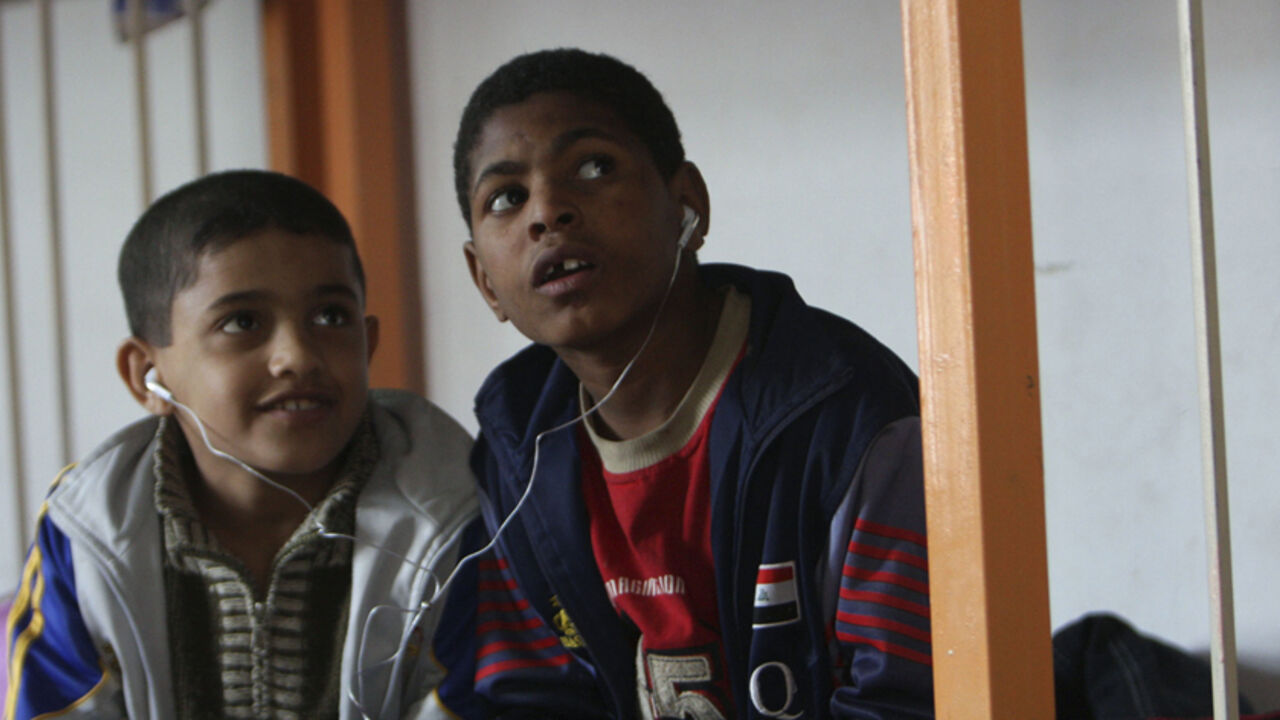 To match feature IRAQ-ORPHANS/ Orphan boys share earphones as they listen to music in their room in the Safe House orphanage in Baghdad's Sadr City February 11, 2009. As violence finally fades and U.S. troops prepare to withdraw, sociologists and health experts say the children's reactions to such trauma could threaten Iraq's fragile calm just as it needs stability to rebuild. Picture taken February 11, 2009. To match feature IRAQ-ORPHANS/ REUTERS/May Naji (IRAQ) - RTXC8UP