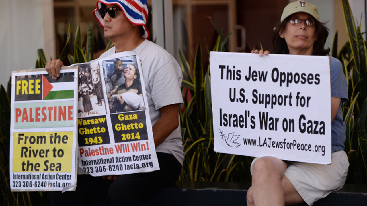 Was8857829 A Jewish peace activist (R) watches a rally by Palestine Americans and their supporters during their protest march against the ongoing conflict in Gaza on August 16, 2014 in Los Angeles. Israel secured supplies of ammunition from the Pentagon last month without the approval of the White House or the State Department. President Barack Obama's administration, caught off guard as it tried to restrain Israel's campaign in Gaza, has since tightened controls on arms shipments to Israel. AFP PHOTO/Mark RALST
