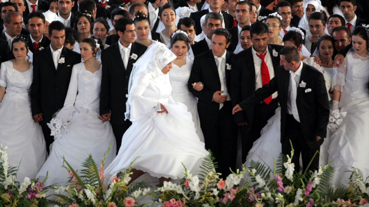 Brides and bridegrooms gather on a stage as they wait for their wedding ceremony in Ankara Brides and bridegrooms gather on a stage as they wait for their wedding ceremony in Ankara August 6, 2006. The 206 couples got married in an annual ceremony organised by Ankara municipality. REUTERS/Umit Bektas (TURKEY) - RTR1G5NN