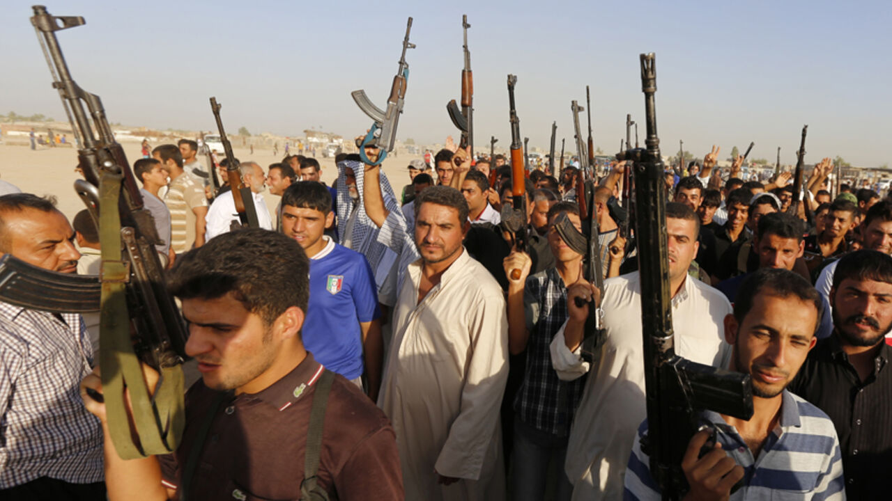 IRAQ-SECURITY/ Volunteers, who have joined the Iraqi Army to fight against predominantly Sunni militants from the radical Islamic State of Iraq and the Levant (ISIL), carry weapons during a parade in the streets in Al-Fdhiliya district, eastern Baghdad June 15, 2014. The insurgent offensive that has threatened to dismember Iraq spread to the northwest of the country on Sunday, when Sunni militants launched a dawn raid on a town close to the Syrian border, clashing with police and government forces. REUTERS/Thaier Al-Suda