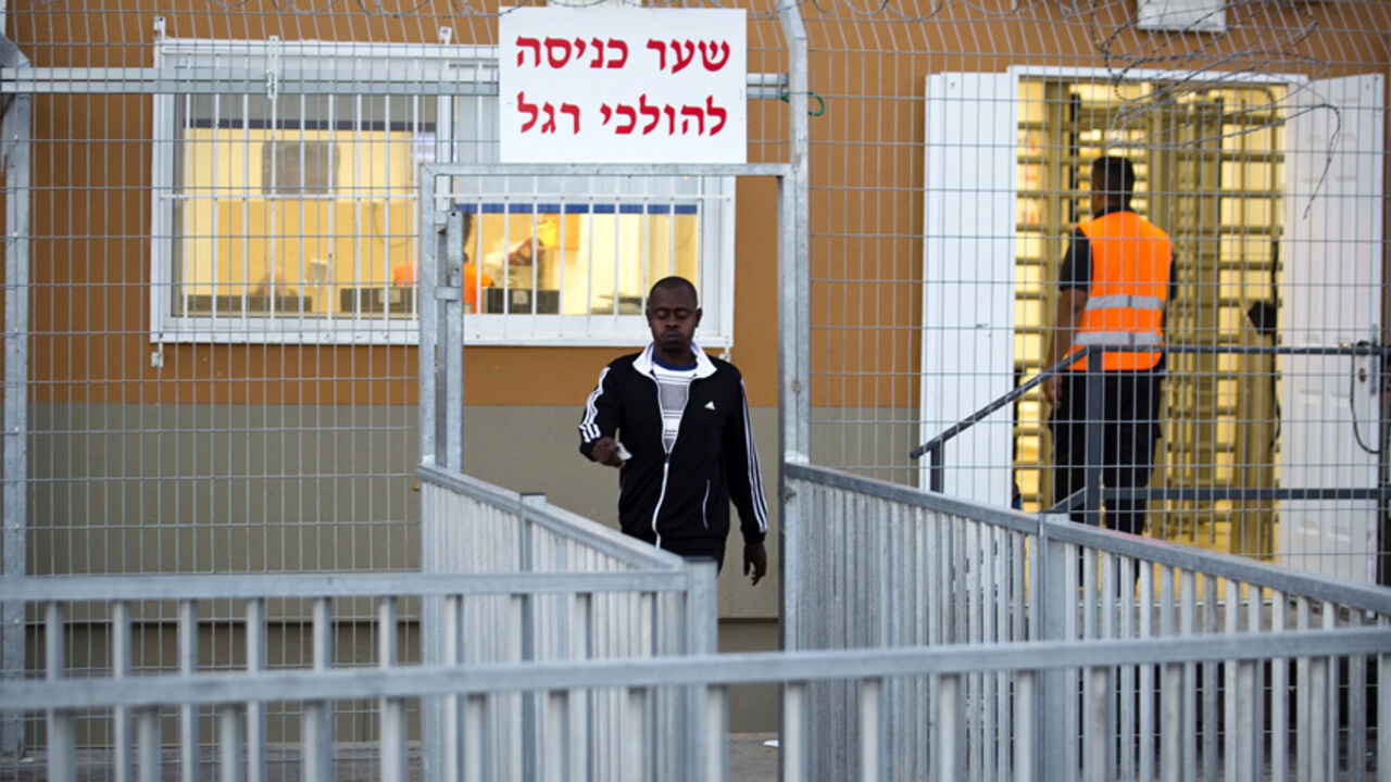 An African migrant walks outside the Holot open detention centre in Israel's southern Negev desert An African migrant walks outside the Holot open detention centre in Israel's southern Negev desert September 22, 2014. Israel's high court on Monday outlawed a detention centre where African migrants are held without trial and ordered some 2,000 inmates there released over the next three months. REUTERS/ Amir Cohen (ISRAEL - Tags: POLITICS SOCIETY IMMIGRATION) - RTR47A6X