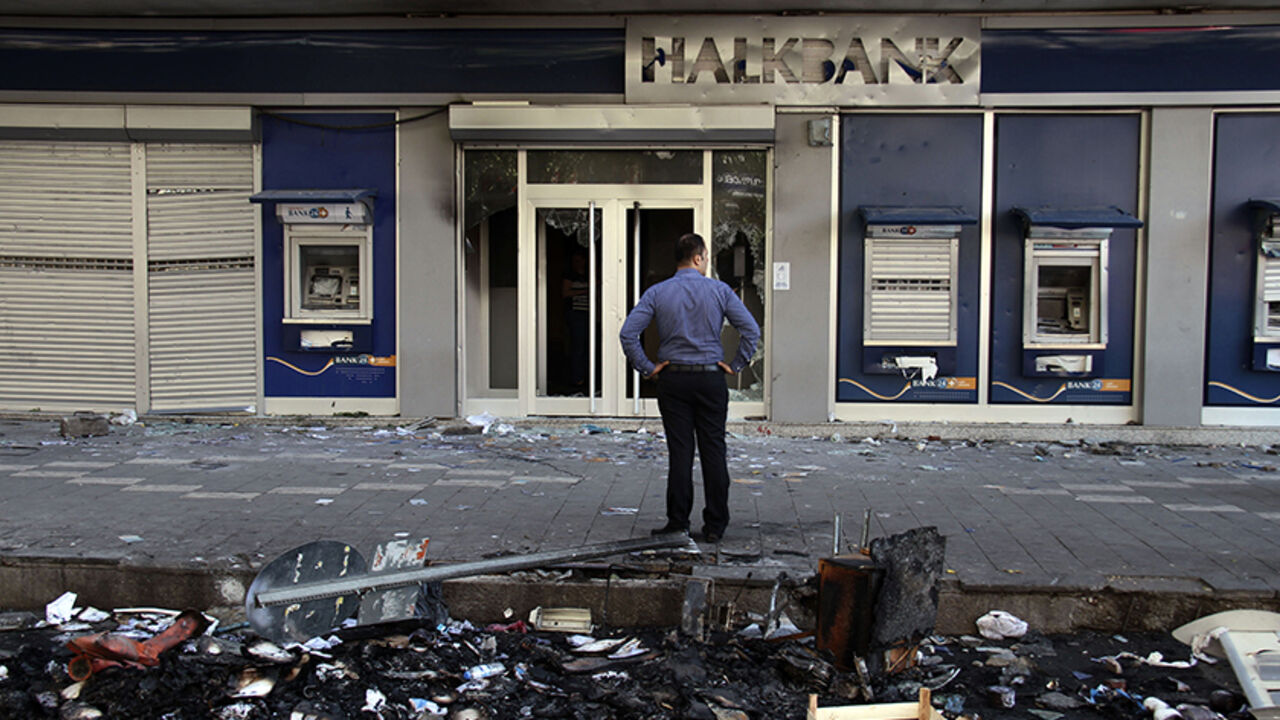 Man looks at a damaged branch of Halkbank, set on fire during clashes between Kurdish protesters and riot police overnight, in Diyarbakir A man looks at a damaged branch of Halkbank, set on fire during clashes between Kurdish protesters and riot police overnight, in Diyarbakir October 8, 2014. At least 12 people died on Tuesday during violent clashes across Turkey, local media reported, as the fate of the besieged Syrian border town of Kobani stirred up decades of tensions with Turkey's Kurdish minority. Violence erupted in Turkish towns and cities mainly in the Kurdish southeastern provinces, as protesters took to the streets to demand the g