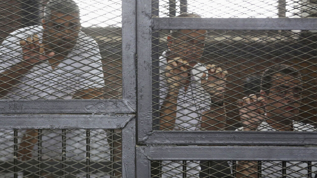 Al Jazeera journalists Mohammed Fahmy, Peter Greste and Baher Mohamed stand behind bars at a court in Cairo Al Jazeera journalists (L-R) Mohammed Fahmy, Peter Greste and Baher Mohamed stand behind bars at a court in Cairo May 15, 2014. The trial of the three Al Jazeera journalists accused of aiding of a "terrorist organisation" has been postponed to May 22 after the judge on Thursday authorised the defence to examine the evidence being held by the prosecution. The Qatar-based television network's journalists - Peter Greste, an Australian, Mohamed Fahmy, a Canadian-Egyptian national, and Baher Mohamed, an Egyptian