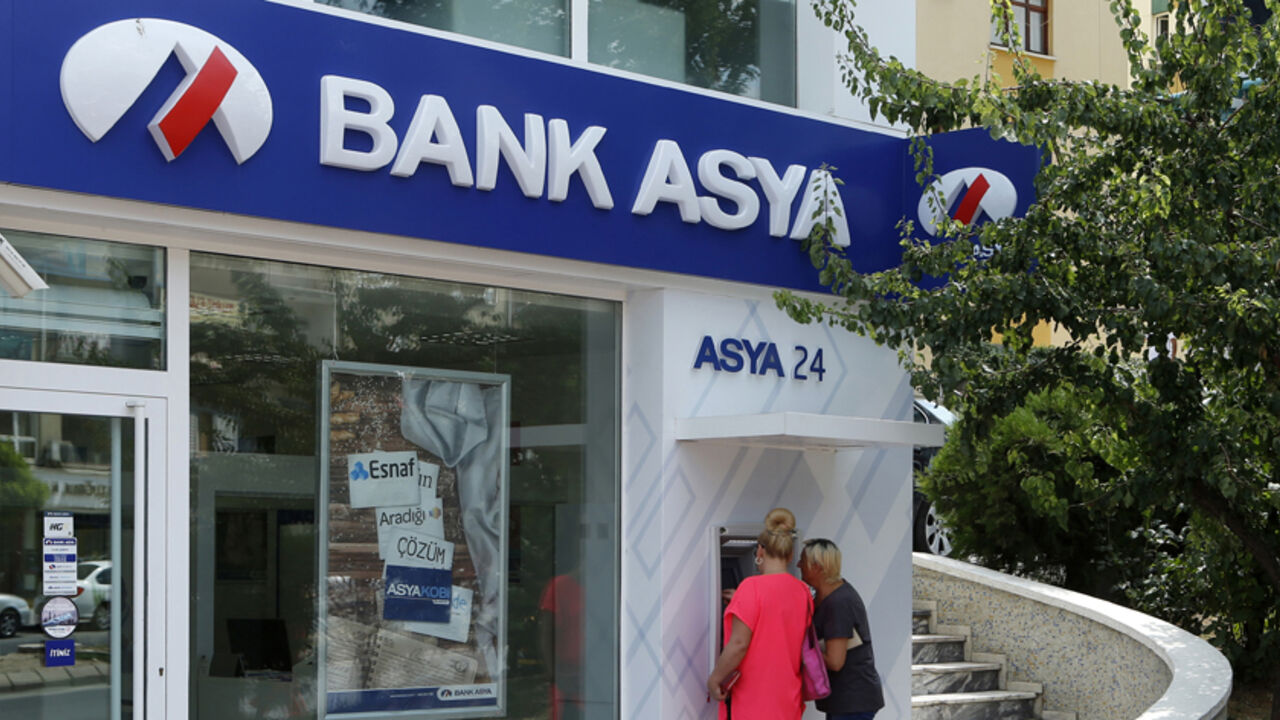 Customers use an ATM machine at a branch of Bank Asya in Ankara Customers use an ATM machine at a branch of Bank Asya in Ankara August 12, 2014. Turkish Islamic lender Bank Asya said its second-quarter net profit fell 81 percent to 10.6 million lira ($4.9 million) as its deposit base shrank and lending wilted under pressure from the government. The lender has seen its profits and capital base collapse since December when it found itself at the centre of a power struggle between Prime Minister Tayyip Erdogan and his political foe Fethullah Gulen, an Islamic cleric whose