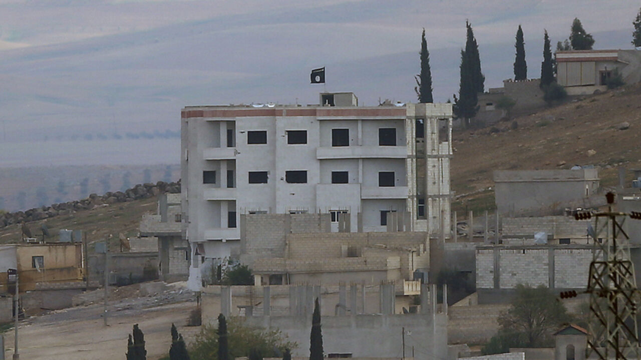 An Islamic State flag is seen in east Kobani An Islamic State flag is seen atop a building in eastern Kobani, as seen from the Turkish border crossing of Mursitpinar as Kurdish Peshmerga forces fight against Islamic state fighters, November 1, 2014. Iraqi Kurdish forces arrived in the Syrian town of Kobani with heavy weapons to help Syrian Kurds fend off attempts by Islamic State insurgents to seize the town and cement control in the Turkish border region. REUTERS/Yannis Behrakis (TURKEY - Tags: MILITARY CONFLICT POLITICS TPX IMAGES OF THE DAY) - RTR