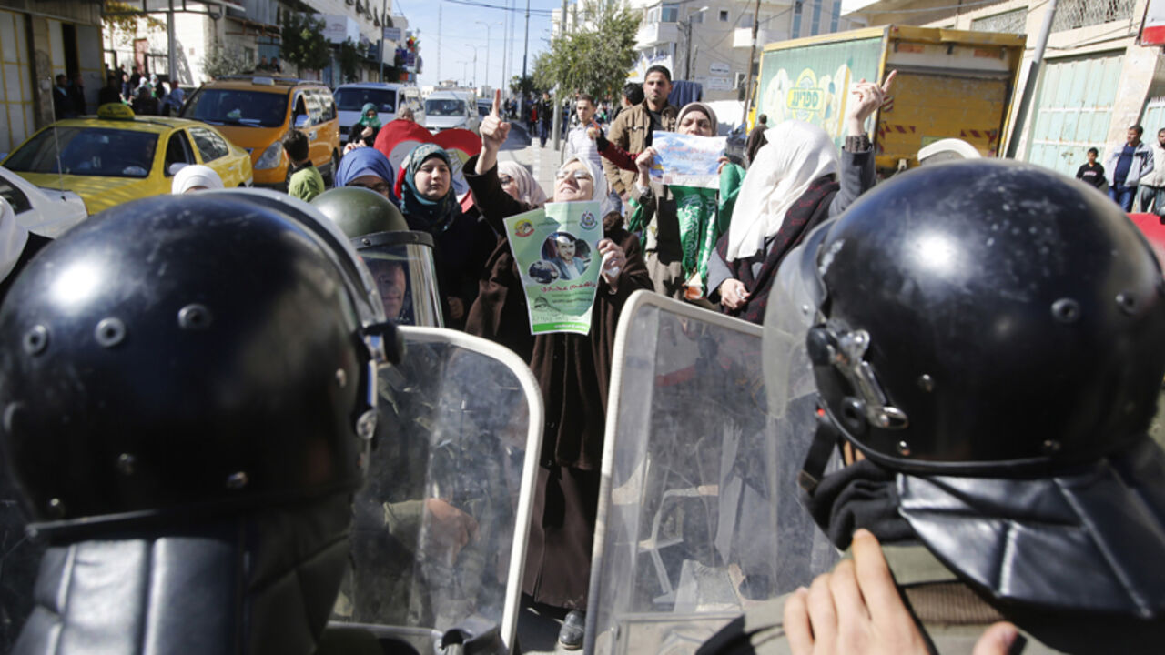 Members of Palestinian security forces take position as Palestinian women take part in an anti-Israel protest against what organizers say are recent visits by Jewish activists to al-Aqsa mosque, in the West Bank city of Hebron November 7, 2014. In recent months, a campaign for the prayer ban on Jewish worshippers at the site, known to Muslims as the Noble Sanctuary and to Jews as Temple Mount, to be overturned, led by settler activists, has gathered momentum, raising alarm among Palestinians and Muslims fur