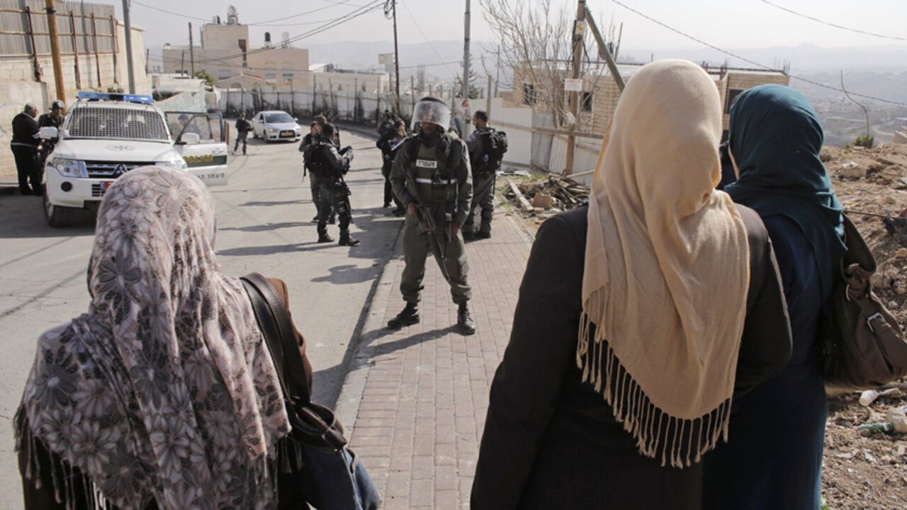Palestinian women stand in front of Israeli border police officers in the Jerusalem district of Jabal Mukaber Palestinian women stand in front of Israeli border police officers in the Jerusalem district of Jabal Mukaber November 18, 2014. Two Palestinians, Ghassan and Udai Abu Jamal, cousins from Jabal Mukaber, armed with a meat cleaver and a gun killed four worshippers in a Jerusalem synagogue on Tuesday before being shot dead by police, the deadliest such incident in six years in the holy city amid a surge in religious conflict. REUTERS/Ammar Awad (JERUSALEM - Tags: CIVIL UNREST POLITICS MILITARY) - RTR4EL5A