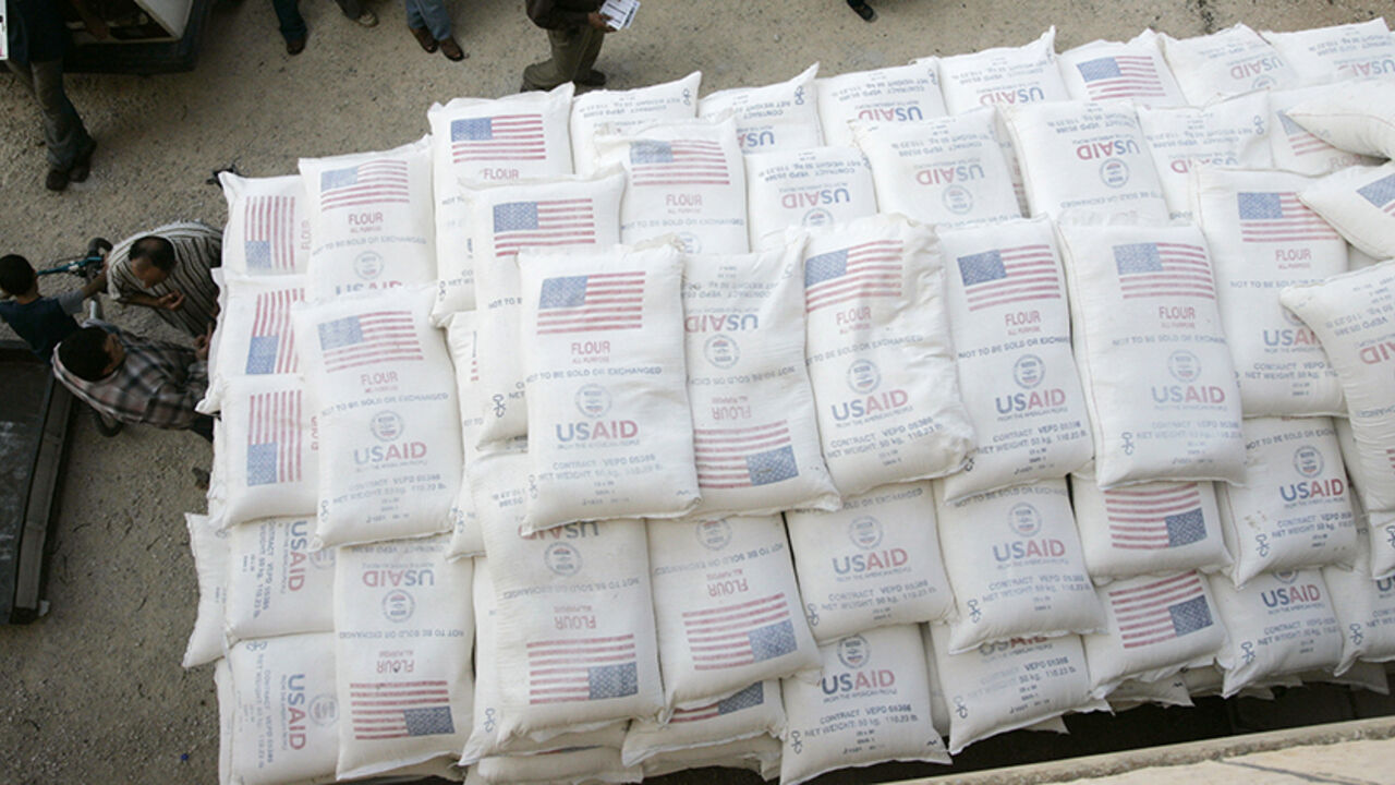 Palestinians stand beside truck in Anin Palestinians stand beside a truck loaded with sacks of flour received from The United States Agency for International Development (USAID) in the village of Anin near the West Bank city of Jenin June 4, 2008. REUTERS/Mohamad Torokman (WEST BANK) - RTX6I8P
