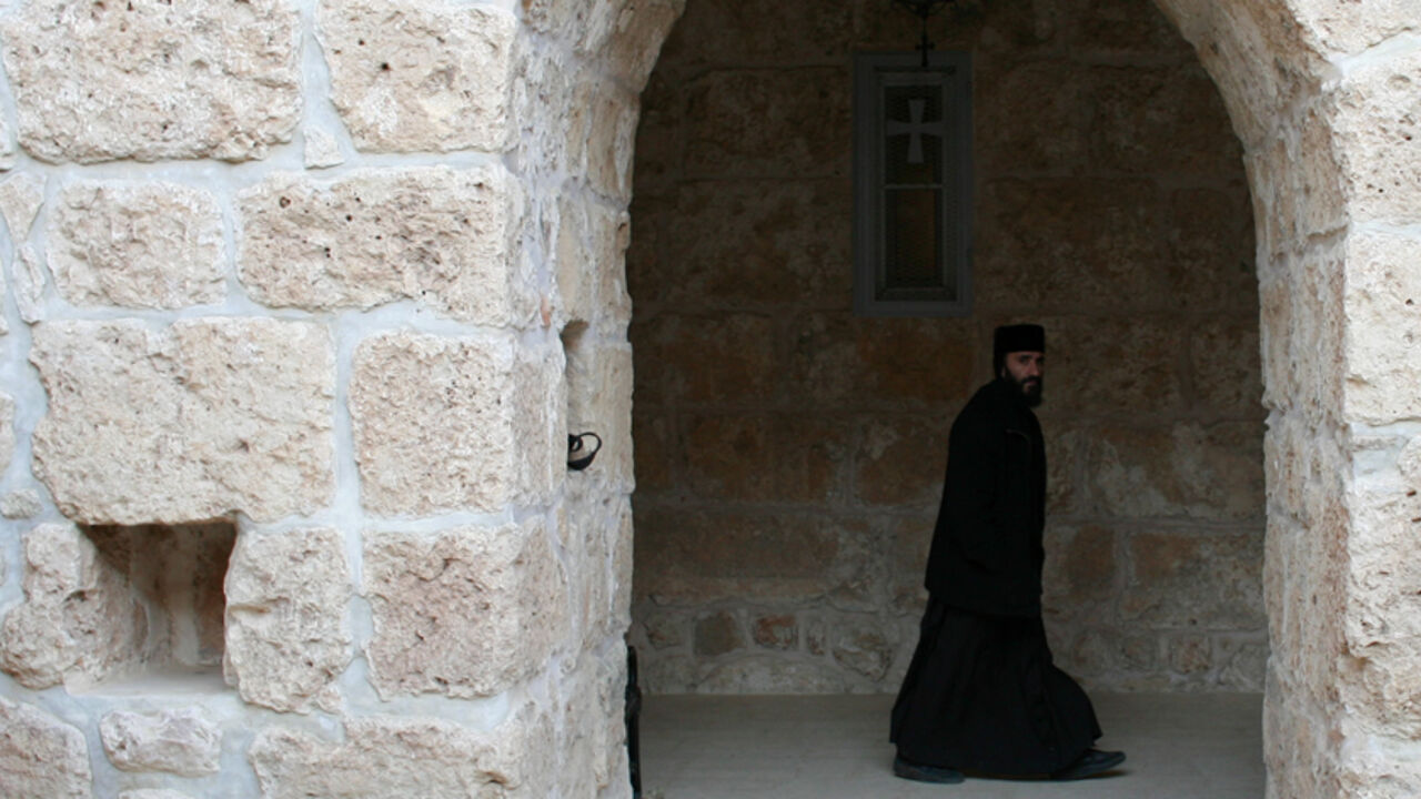 RELIGION-TURKEY/CHRISTIANS A Syriac Christian monk walks to attend a service at the ancient monastery of Mor Gabriel, 15 km (9 miles) from the town of Midyat, in Mardin province of southeast Turkey January 13, 2009. Tucked amid rugged hills where mosques and minarets are silhouetted in the distance, the fifth century Mor Gabriel monastery stands out as a relic of another era when hundreds of thousands of Syriac Christians lived and worshipped in Turkey. But a land dispute between Mor Gabriel and neighbouring villages is threatening t