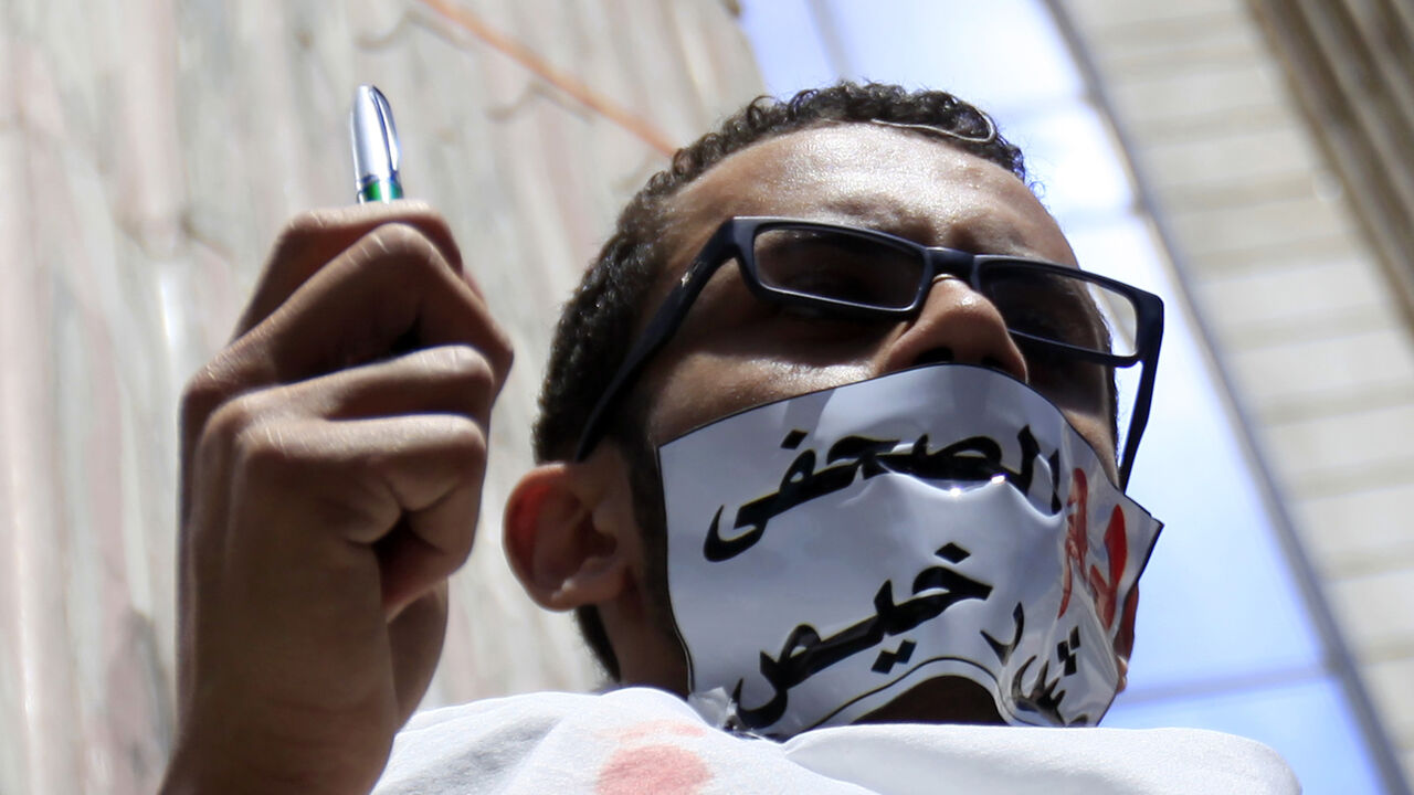 A journalist with his mouth taped holds a pen during a protest against the Interior Ministry in front of the Press Syndicate in Cairo April 17, 2014. Protesters accused the ministry on Thursday of deliberately targeting journalists during their coverage of violence and conflict. The tape reads, "The blood of a journalist is not cheap." REUTERS/Amr Abdallah Dalsh (EGYPT - Tags: POLITICS CIVIL UNREST MEDIA) - RTR3LOW1