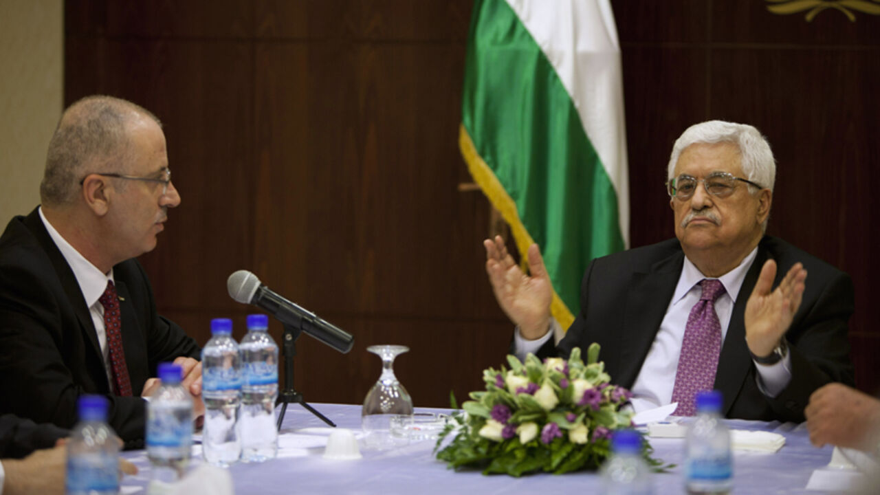 PALESTINIAN-UNITY/ Palestinian President Mahmoud Abbas (R) meets with Palestinian Prime Minister Rami Hamdallah and ministers of the unity government, in the West Bank city of Ramallah June 2, 2014. Abbas swore in a Palestinian unity government on Monday under a reconciliation deal with Hamas Islamists that led Israel to freeze U.S.-brokered peace talks with the Western-backed leader. REUTERS/Majdi Mohammed/Pool (WEST BANK - Tags: POLITICS) - RTR3RU64