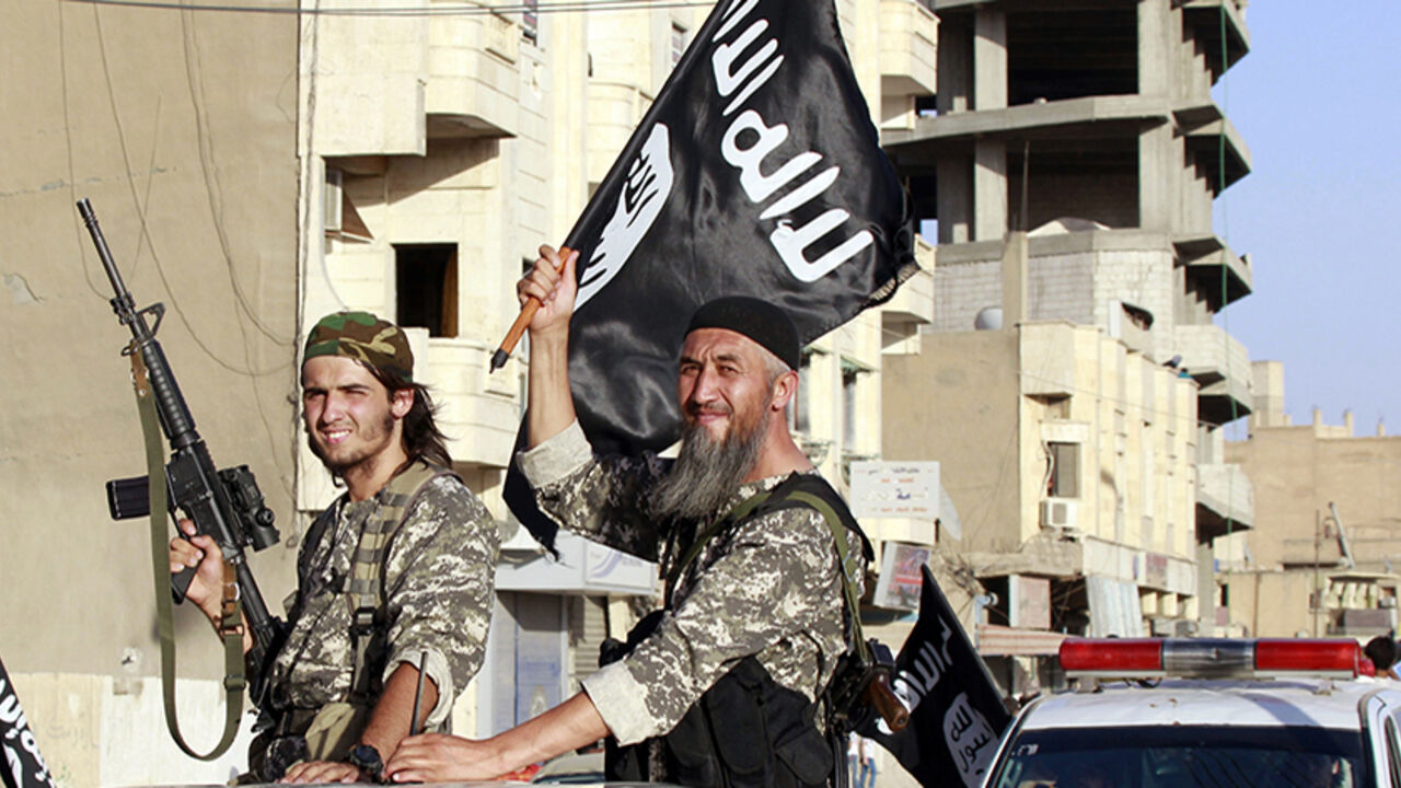Militant Islamist fighters wave flags as they take part in a military parade along the streets of Syria's northern Raqqa province Militant Islamist fighters wave flags as they take part in a military parade along the streets of Syria's northern Raqqa province June 30, 2014. The fighters held the parade to celebrate their declaration of an Islamic "caliphate" after the group captured territory in neighbouring Iraq, a monitoring service said. The Islamic State, an al Qaeda offshoot previously known as Islamic State in Iraq and the Levant (ISIL), posted pictures online on Sunday of people waving black flags from cars and holding guns in