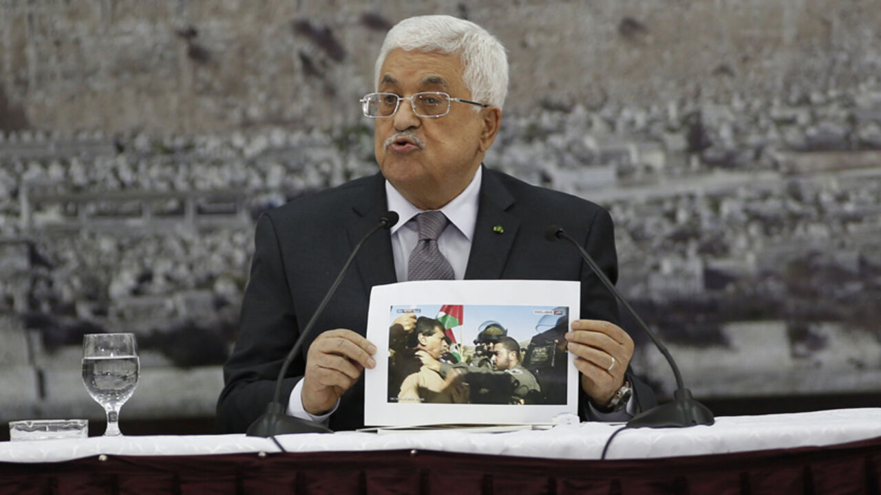 MIDEAST-ISRAEL/PALESTINIANS Palestinian President Mahmoud Abbas shows a picture of Palestinian minister Ziad Abu Ein as he is grabbed by an Israeli border policeman, during a meeting with the Palestinian leadership in the West Bank city of Ramallah December 10, 2014. Abu Ein died on Wednesday shortly after the Israeli border policeman shoved and grabbed him by the throat during the protest in the West Bank, an incident Abbas described as barbaric. Abu Ein, 55, a minister without portfolio, was among scores of Palestinian and foreign a