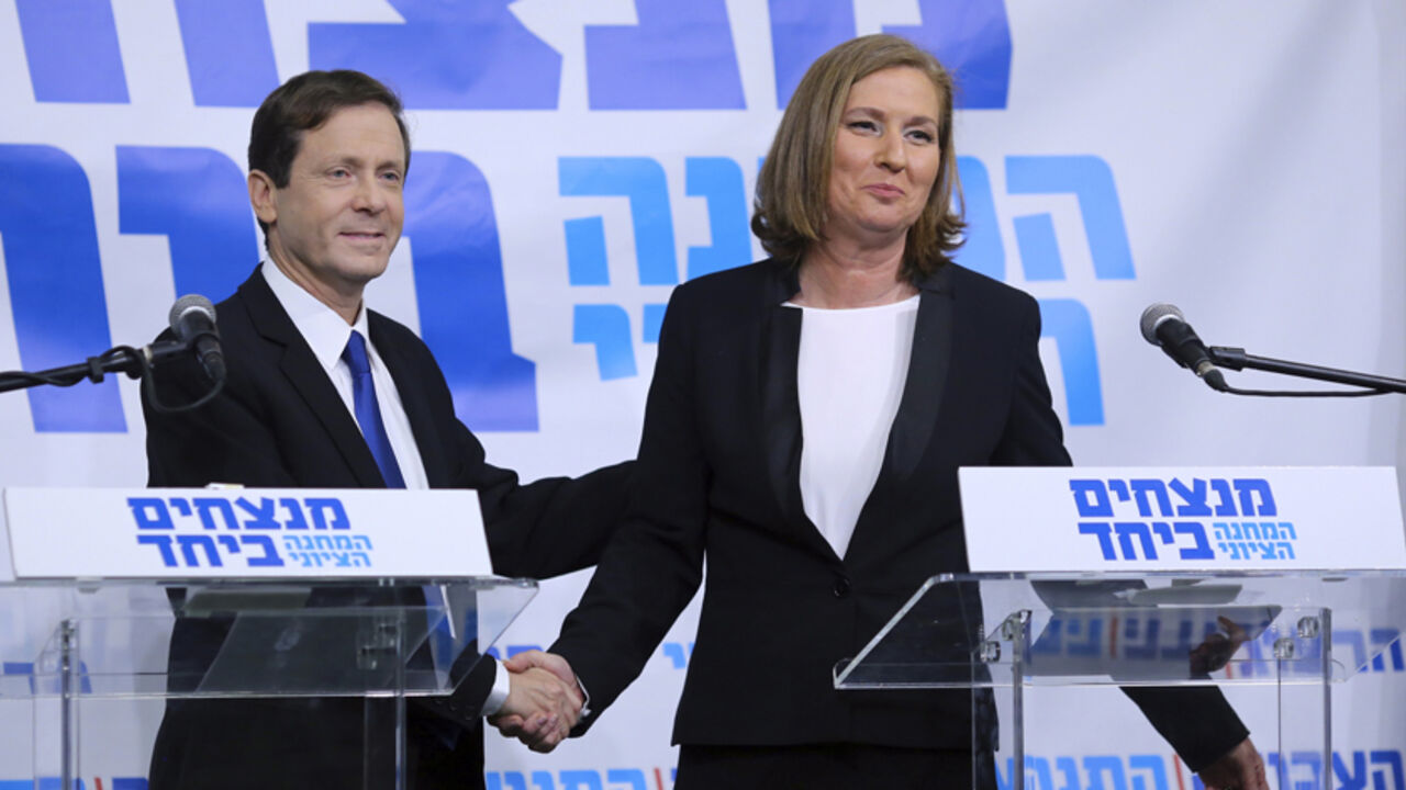 Issac Herzog (L), leader of Israel's Labour party, and former Israeli Justice Minister Tzipi Livni shake hands after their joint news conference in Tel Aviv December 10, 2014. Livni and the center-left parliamentary opposition leader formed a joint election ticket on Wednesday that polls show could pose a serious challenge to Prime Minister Benjamin Netanyahu in March.  REUTERS/Stringer (ISRAEL - Tags: POLITICS ELECTIONS) - RTR4HICW