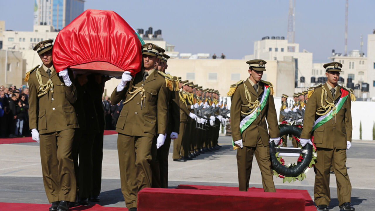 Palestinian honor guards carry the coffin of Palestinian minister Ziad Abu Ein during his funeral in the West Bank city of Ramallah December 11, 2014. Thousands of mourners turned out on Thursday for a Palestinian state funeral for a minister who died after being grabbed by the neck by an Israeli policeman at a West Bank protest, an incident that has raised tensions with Israel. Israeli and Palestinian officials issued conflicting accounts over the results of a joint Palestinian, Jordanian and Israeli autop