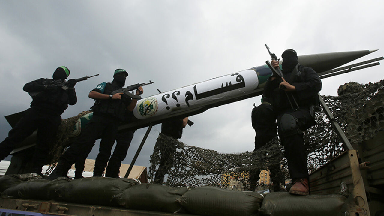MIDEAST-PALESTINIANS/ISRAEL Palestinian members of al-Qassam Brigades, the armed wing of the Hamas movement, display a home-made Qassam rocket during a military parade marking the 27th anniversary of Hamas' founding, in Gaza City December 14, 2014. REUTERS/Suhaib Salem (GAZA - Tags: POLITICS MILITARY ANNIVERSARY) - RTR4HXKR