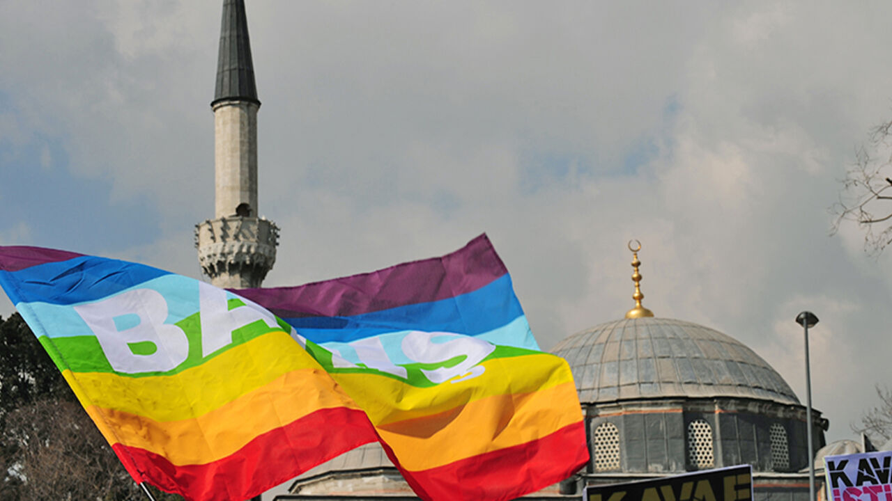 Par3123217 Turkish gay rights group (LAMBDA) activists wave peace flags infront of a mosque in Istanbul on March 16, 2010 during a demonstration against Family Affairs Minister Aliye Selma Kavaf. Some 60 activists denounced Kavaf and called for her resignation, as they accuse the Family Affairs Minister of insult, incitement to crime and incitement to enmity and hate -- crimes which are punishable by up to two, five and three years in jail respectively. Kavaf, who is also women's minister in the Islamist-rooted gover