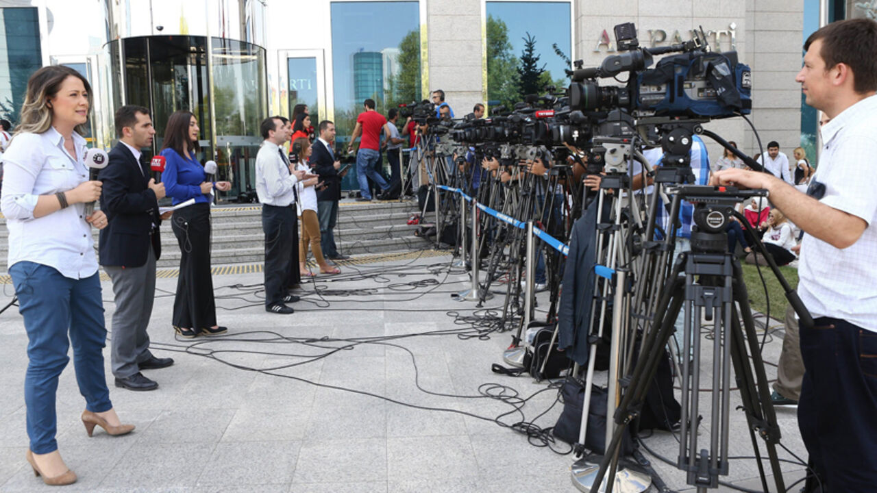 Par7954528 Television journalists report from outside the headquarters of Turkey's ruling Justice and Development Party (AKP) party, shortly before the country's president-elect announces the name of his party's new chairman, in Ankara, on August 21, 2014. Turkey's ruling party is meeting on August 21 to agree on a new leader and prime minister to replace incoming president Recep Tayyip Erdogan, with Foreign Minister Ahmet Davutoglu the frontrunner for the job.AFP PHOTO / ADEM ALTAN (Photo credit should read AD