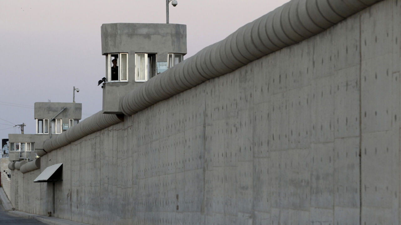 JORDAN/ Jordanian prison guards stand guard at Um Alluol prison in the city of Mafraq, northeast of Amman, August 7, 2012. Jordan's prison administration have taken an initiative, which allows prisoners to have meals with their families, and also presenting them with gifts and incentive awards for their participation in activities at the prison, during the month of Ramadan. REUTERS/Muhammad Hamed (JORDAN - Tags: CRIME LAW SOCIETY) - RTR36EPW