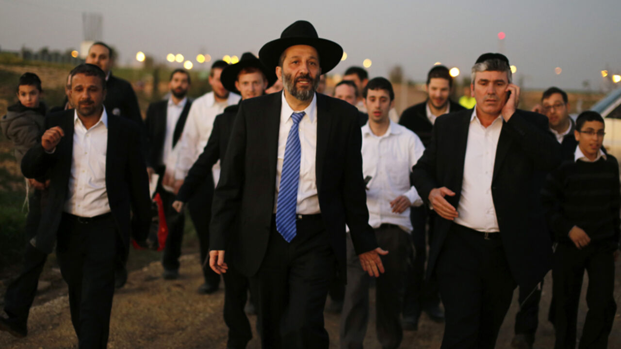 Aryeh Deri (C), leader of the ultra-Orthodox Shas party, attends an annual pilgrimage to the gravesite of Rabbi Yisrael Abuhatzeira, a Moroccan-born sage and kabbalist also known as the Baba Sali, in the southern town of Netivot January 14, 2013.  Powerful political players for years, Israel's ultra-Orthodox parties must now reckon with a new force ushered in by voters bent on stripping them of perks they have relied on for decades. Picture taken January 14, 2013. REUTERS/Amir Cohen (ISRAEL - Tags: POLITICS