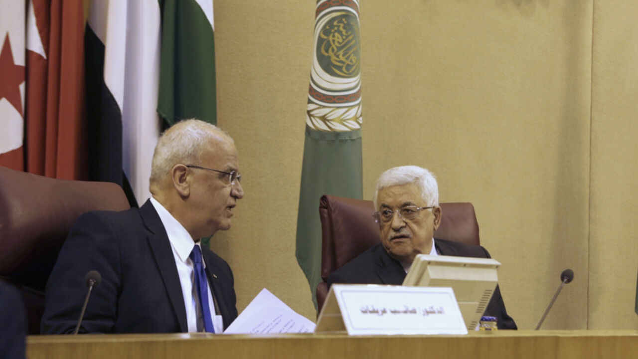 EGYPT/ Palestinian President Mahmoud Abbas (R) talks with Palestinian chief negotiator Saeb Erekat as they attend an Arab Foreign Ministers' meeting at the Arab League headquarters in Cairo April 9, 2014. REUTERS/Asmaa Waguih (EGYPT - Tags: POLITICS) - RTR3KJSQ